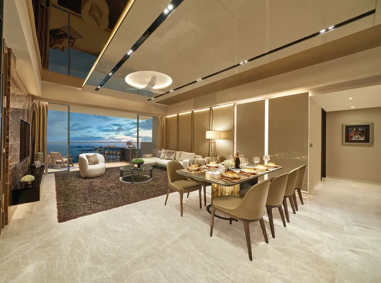 Newport Residences, interior photograph for illustration only: a living and dining room with a marble floor, a long dining table and full-height glazing onto a balcony over the sea